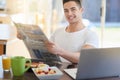 I believe in starting my day leisurely. a young man reading the morning paper while having breakfast. Royalty Free Stock Photo