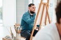I can be creative through art. a handsome young artist sitting and painting during an art class in the studio. Royalty Free Stock Photo