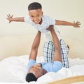 I can fly. a young father lying down and bonding with his son while playing with him at home. Royalty Free Stock Photo