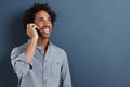 I can hear you just fine. a happy young man talking on a cellphone on a gray background. Royalty Free Stock Photo