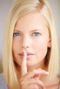 I can keep a secret. Portrait of a young woman holding her finger in front of her lips. Royalty Free Stock Photo