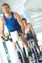 I can keep this up all day. A man and woman exercising in spinning class at the gym. Royalty Free Stock Photo