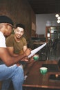 I can tell that you really know your stuff. two young men discussing business while sitting together in a coffee shop. Royalty Free Stock Photo