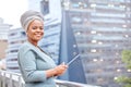 I can work from out here. Shot of a mature businesswoman using a digital tablet against a city background. Royalty Free Stock Photo