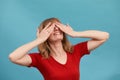 I can't see you. Portrait of pretty woman closing her eyes with two palms, blue studio background Royalty Free Stock Photo