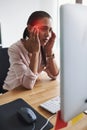 I cant focus with this throbbing pain in my head. a young businesswoman suffering with a headache while working in an Royalty Free Stock Photo