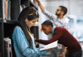 I cant put this book down. Shot of a group young students standing in a library picking out books to read. Royalty Free Stock Photo