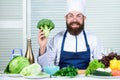 I choose only healthy ingredients. Man cook hat and apron hold broccoli. Healthy nutrition concept. Bearded professional Royalty Free Stock Photo