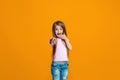 The happy teen girl pointing to you, half length closeup portrait on orange background. Royalty Free Stock Photo