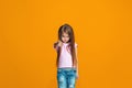 The happy teen girl pointing to you, half length closeup portrait on orange background. Royalty Free Stock Photo