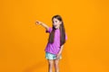 The happy teen girl pointing to you, half length closeup portrait on orange background. Royalty Free Stock Photo