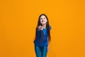 The happy teen girl pointing to you, half length closeup portrait on orange background. Royalty Free Stock Photo