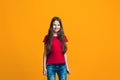 The happy teen girl pointing to you, half length closeup portrait on orange background. Royalty Free Stock Photo