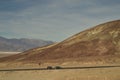 Car and camper on road in vast landscape of Death Valley National Park