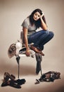 I could really do with a fairy godmother right now. Studio shot of a young woman trying to choose an outfit from a pile