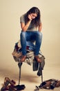 I could really do with a fairy godmother right now. Studio shot of a young woman trying to choose an outfit from a pile