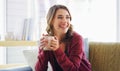 I could stay at home all day. an attractive young woman sitting on her living room couch and holding a cup of coffee. Royalty Free Stock Photo