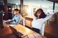 I could use a quick recharge. a young businesswoman relaxing at her desk while working alongside her colleague in an Royalty Free Stock Photo