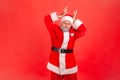 I am deer. Elderly man with gray beard wearing santa claus costume showing deer antler horns over Royalty Free Stock Photo