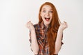 I did it. Happy and surprised redhead girl celebrating victory, screaming with joy and delight, triumphing as winning Royalty Free Stock Photo