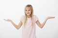 I do not know, I am kid. Portrait of unaware clueless cute girl, shrugging with spread palms, being questioned and Royalty Free Stock Photo