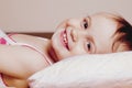 I do not want to sleep yet.Cute active little child girl having fun in bed and doesn`t want going to fall asleep