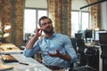 I don`t hear you. Portrait of young bearded man in eyeglasses and headphones talking with client while sitting in the Royalty Free Stock Photo