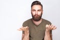 I don`t know! Portrait of confused bearded man with dark green t shirt against light gray background.