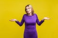 I don`t know, whatever. Portrait of uncertain confused woman shrugging shoulders in bewilderment. isolated on yellow background