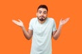 I don`t know, who cares. Portrait of confused clueless brunette man making no idea gesture. isolated on orange background
