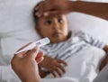 I dont feel so good Mommy. an unrecognisable boy lying in bed and feeling sick while his mother checks his temperature. Royalty Free Stock Photo