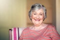 I dont put an age restriction on happiness. Portrait of a happy senior woman relaxing on a chair at home. Royalty Free Stock Photo