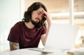 I dont think I can do this. a young businessman looking stressed out while working on a laptop in an office.