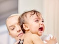 I dont think I like this doctor. a little baby crying while being examined by a doctor.