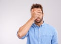 I dont wanna see this. Studio shot of a handsome young man covering his eyes in regret against a gray background.