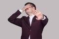 I dont want to see this. Portrait of confused young man in violet suit and white shirt, standing, closed his eyes with hands and Royalty Free Stock Photo