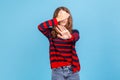 I dont want to see it. Portrait of woman wearing striped casual style sweater covering eyes with Royalty Free Stock Photo