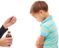 I dont want to. Studio shot of an unhappy young boy being given some medicine on a spoon by his mother. Royalty Free Stock Photo