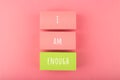 I am enough concept with words written on colorful rectangles against bright pink background. Self love concept