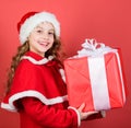 I am so excited. Girl cute child santa costume hold christmas gift box. What is inside. Lets open christmas gift