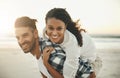 I fell for someone who sets my soul on fire. a young man piggybacking his girlfriend while spending the day at the beach Royalty Free Stock Photo