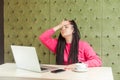 I forget! Portrait of depressed young girl with black dreadlocks hairstyle in pink blouse are sitting in cafe and having big