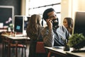 I found your contact details online. a businessman talking on his phone while sitting at his desk.