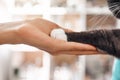 I am a friend for my patient. Close-up photo of female vet hand holding a paw of a black fluffy cat during a checkup in