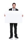 I fully endorse your great product. A handsome young businessman holding a blank board while isolated on white.