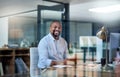 I get more work done in the evenings. Cropped portrait of a handsome mature businessman sitting alone in his office at Royalty Free Stock Photo