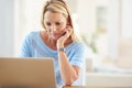 I get more work done when its done from home. an attractive mature woman sitting and using a laptop while in her living Royalty Free Stock Photo