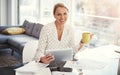 I get to drink coffee and work from home, how great. a mature businesswoman working from her home office. Royalty Free Stock Photo