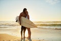 I am happiest when Im with you. Full length shot of a happy young couple with a surfboard sharing a tender moment on the Royalty Free Stock Photo