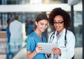 I am happy the results turned out the way they have. two cheerful young doctors working on a digital tablet together Royalty Free Stock Photo